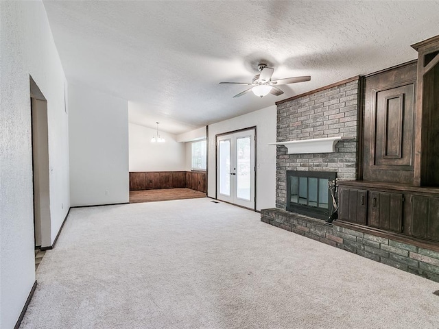 1357 W Cedarbrook Ln, Moore, OK 73170 - unfurnished living room featuring carpet, wooden walls, a ceiling fan, and a textured ceiling