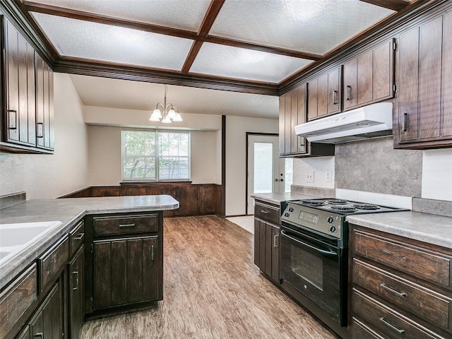1357 W Cedarbrook Ln, Moore, OK 73170 - kitchen with dark brown cabinetry, an inviting chandelier, light wood-style flooring, under cabinet range hood, and black electric range