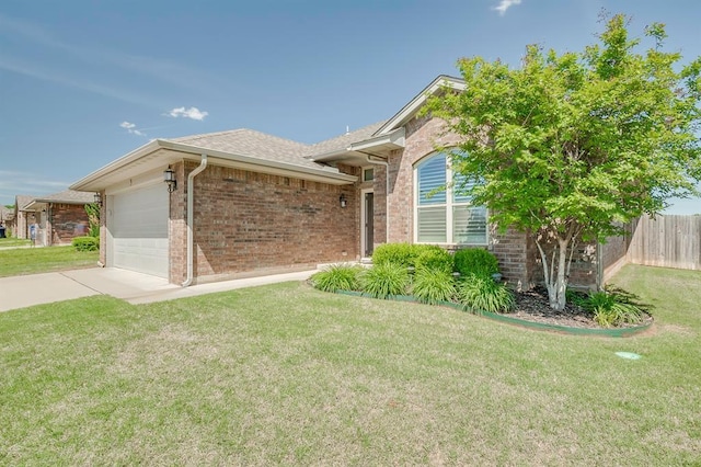 single story home with fence, a front yard, brick siding, an attached garage, and driveway