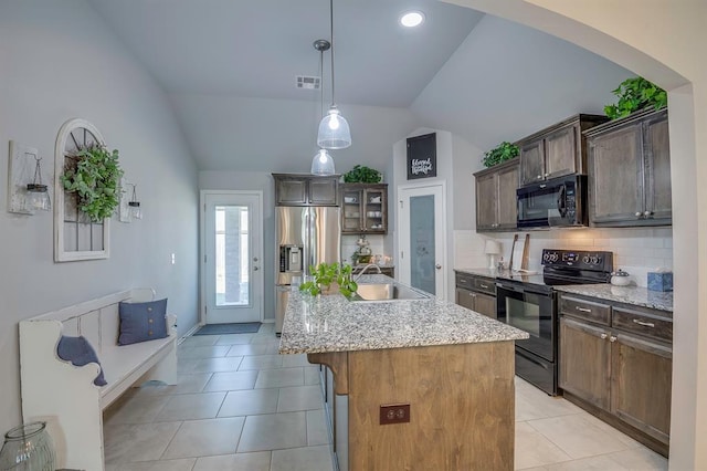 kitchen with visible vents, light tile patterned floors, a sink, black appliances, and lofted ceiling
