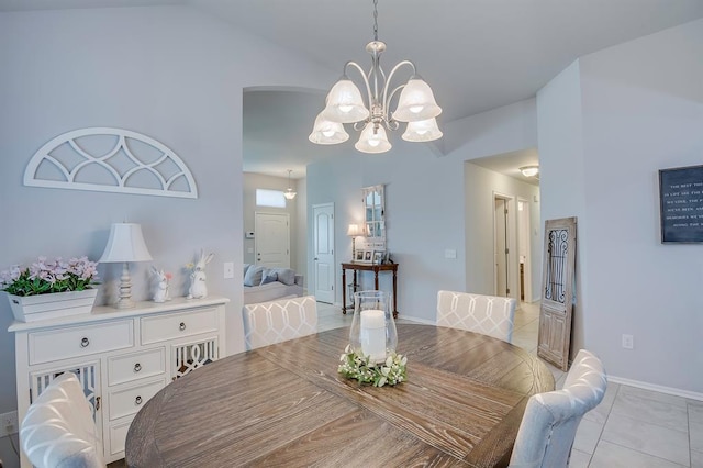 dining room with an inviting chandelier, baseboards, light tile patterned floors, and vaulted ceiling