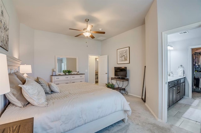 bedroom featuring visible vents, baseboards, light colored carpet, a spacious closet, and a ceiling fan