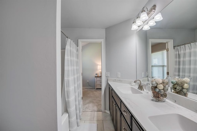 bathroom with double vanity, a sink, and tile patterned flooring
