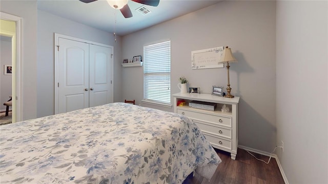 bedroom with visible vents, a closet, baseboards, dark wood-type flooring, and a ceiling fan