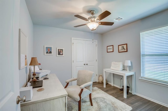 office featuring visible vents, baseboards, ceiling fan, and wood finished floors