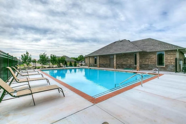 community pool with fence and a patio area