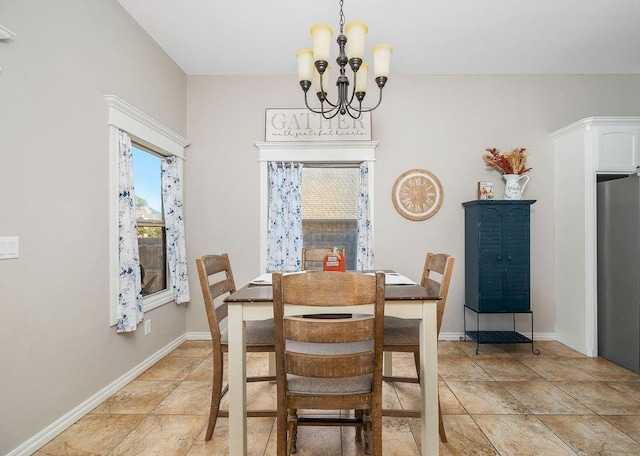 dining room with stone finish flooring, baseboards, and a notable chandelier