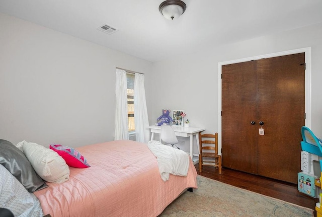 bedroom with visible vents and wood finished floors