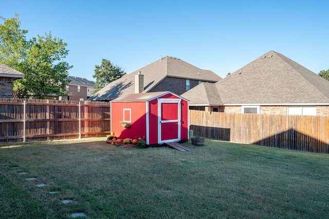 view of yard with an outbuilding, a fenced backyard, and a storage shed