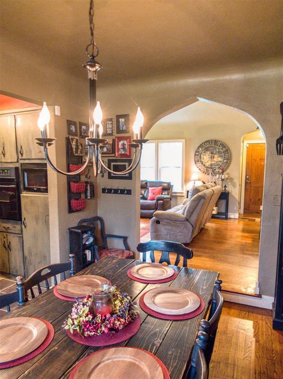 1818 N Union Ave, Shawnee, OK 74804 - dining space with arched walkways, wood finished floors, and a chandelier