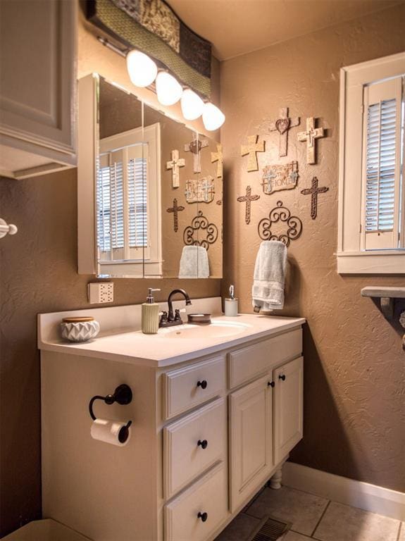 1818 N Union Ave, Shawnee, OK 74804 - bathroom featuring vanity, a textured wall, tile patterned floors, and baseboards