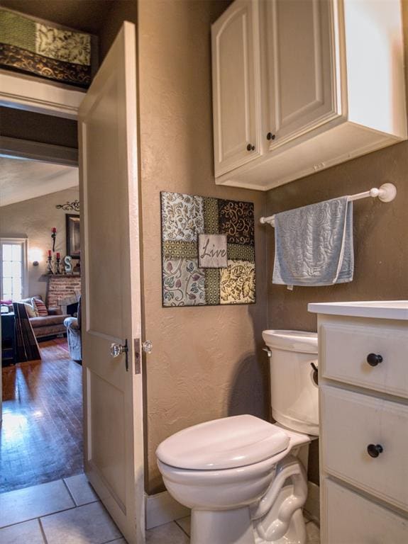 1818 N Union Ave, Shawnee, OK 74804 - bathroom with toilet, a textured wall, a fireplace, and tile patterned flooring