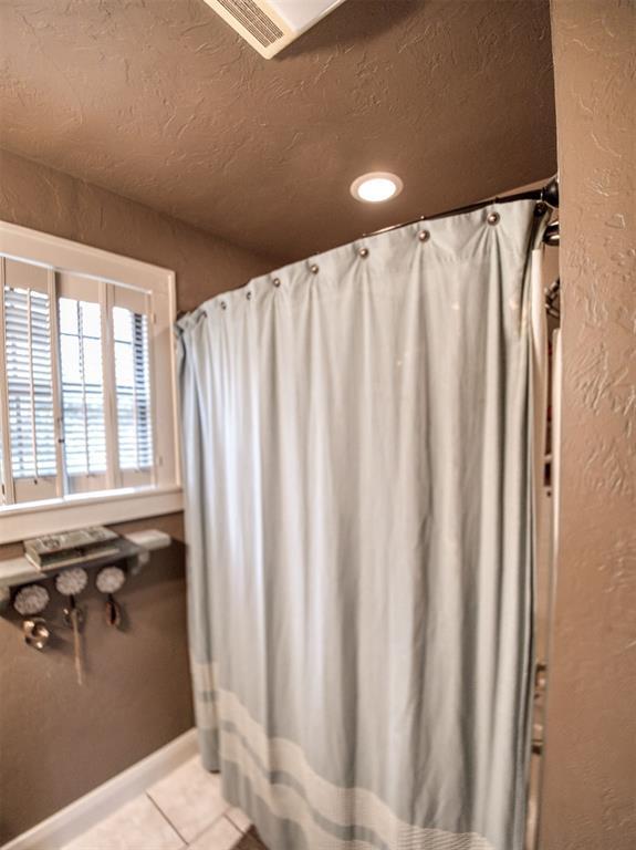 1818 N Union Ave, Shawnee, OK 74804 - bathroom with tile patterned floors, a textured ceiling, recessed lighting, and a textured wall