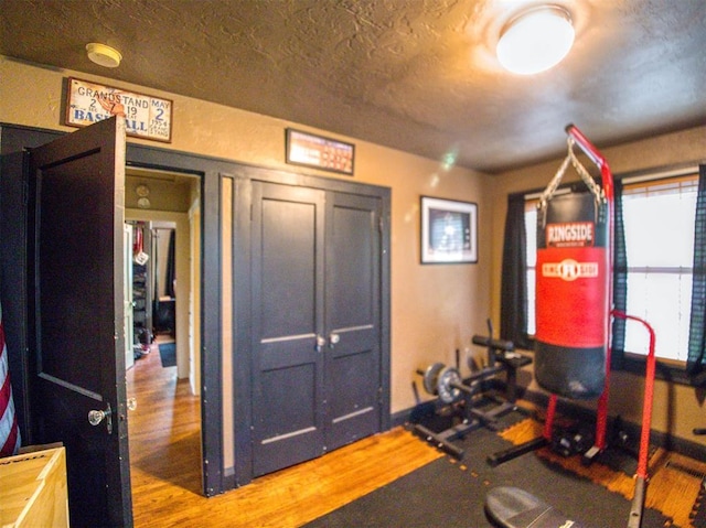 1818 N Union Ave, Shawnee, OK 74804 - exercise area featuring wood finished floors, baseboards, and a textured ceiling
