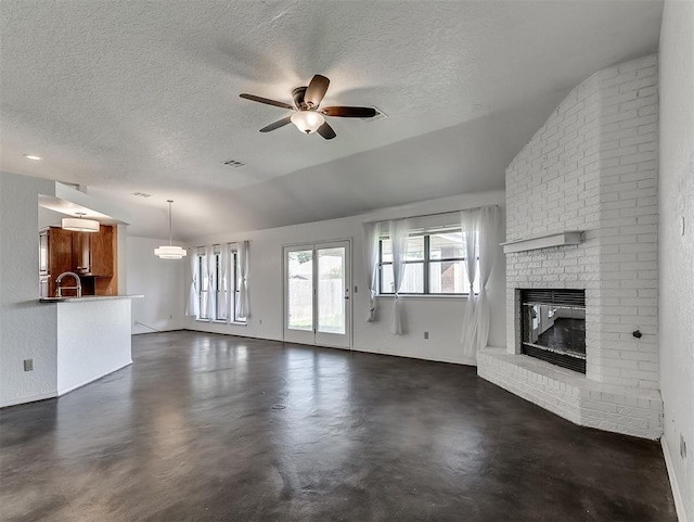1621 Park View Pl, Edmond, OK 73003 - unfurnished living room with ceiling fan, a fireplace, vaulted ceiling, and a textured ceiling