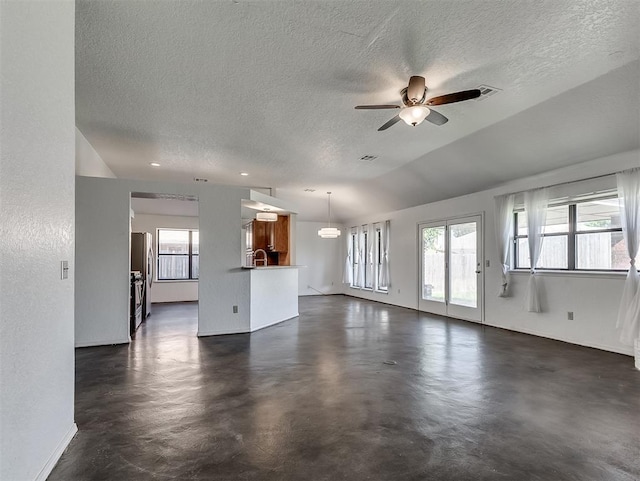 1621 Park View Pl, Edmond, OK 73003 - unfurnished living room with a healthy amount of sunlight, baseboards, ceiling fan, and a textured ceiling