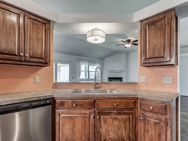 1621 Park View Pl, Edmond, OK 73003 - kitchen featuring a ceiling fan, stainless steel dishwasher, a brick fireplace, a sink, and lofted ceiling