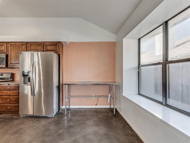 1621 Park View Pl, Edmond, OK 73003 - kitchen with brown cabinetry, finished concrete flooring, vaulted ceiling, baseboards, and stainless steel appliances