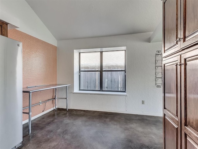 1621 Park View Pl, Edmond, OK 73003 - empty room featuring baseboards, a textured wall, concrete flooring, and vaulted ceiling