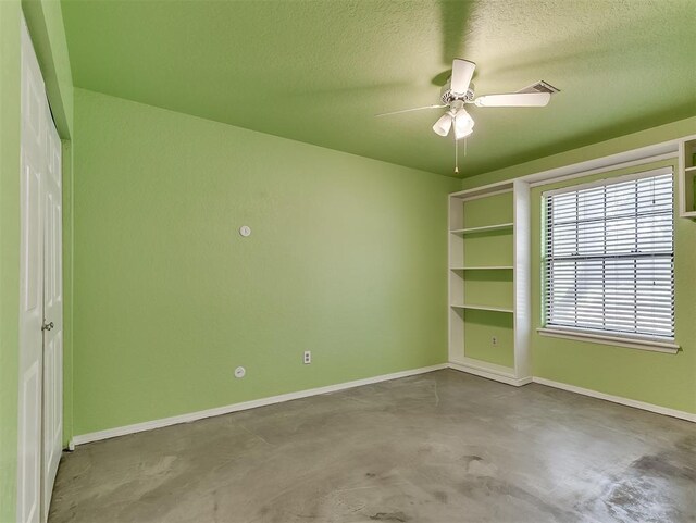 1621 Park View Pl, Edmond, OK 73003 - unfurnished room featuring baseboards, ceiling fan, concrete floors, and a textured ceiling