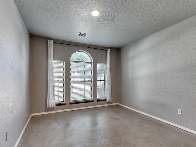 1621 Park View Pl, Edmond, OK 73003 - unfurnished room with baseboards, a textured ceiling, concrete floors, and a textured wall