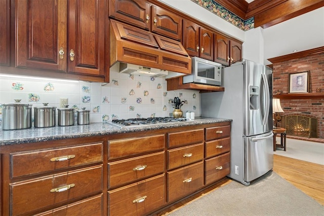 4200 Oakdale Farm Cir, Edmond, OK 73013 - kitchen with backsplash, light wood finished floors, dark stone countertops, and appliances with stainless steel finishes