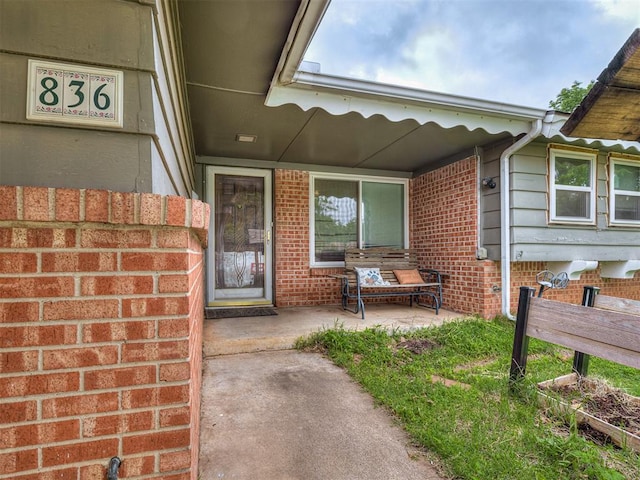 view of exterior entry with brick siding
