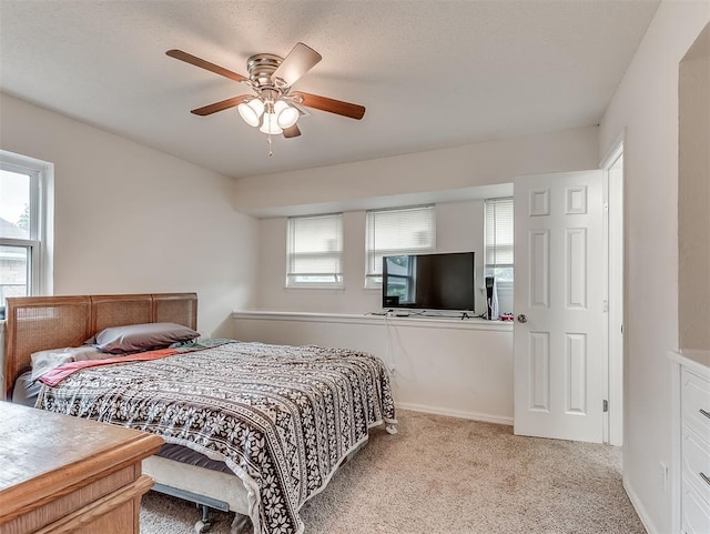 bedroom with a ceiling fan and light colored carpet