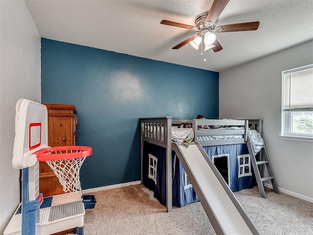 bedroom featuring carpet flooring, a textured ceiling, and ceiling fan