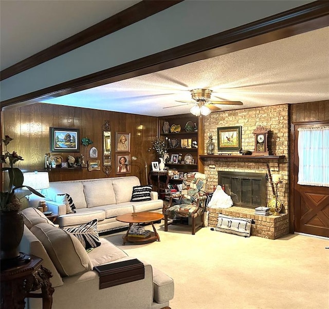 living area featuring carpet floors, ceiling fan, a fireplace, and wood walls