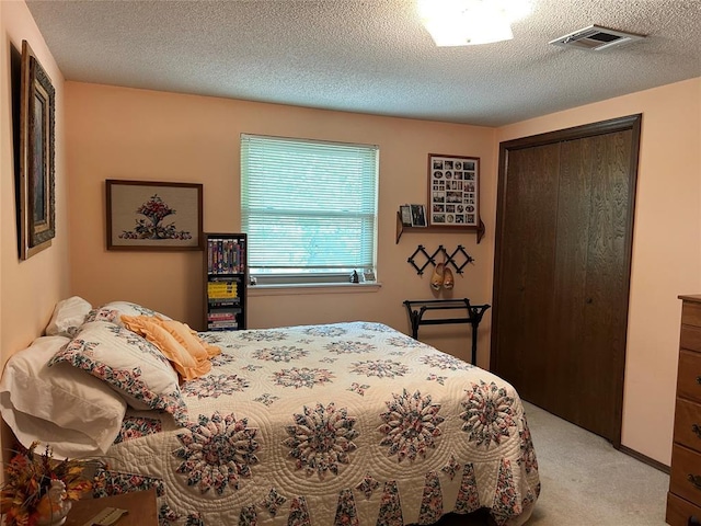 bedroom featuring light carpet, a closet, a textured ceiling, and visible vents