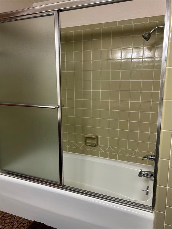 bathroom featuring bath / shower combo with glass door