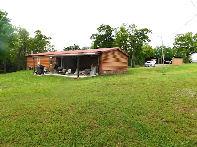 exterior space with a lawn, a patio area, and a detached carport