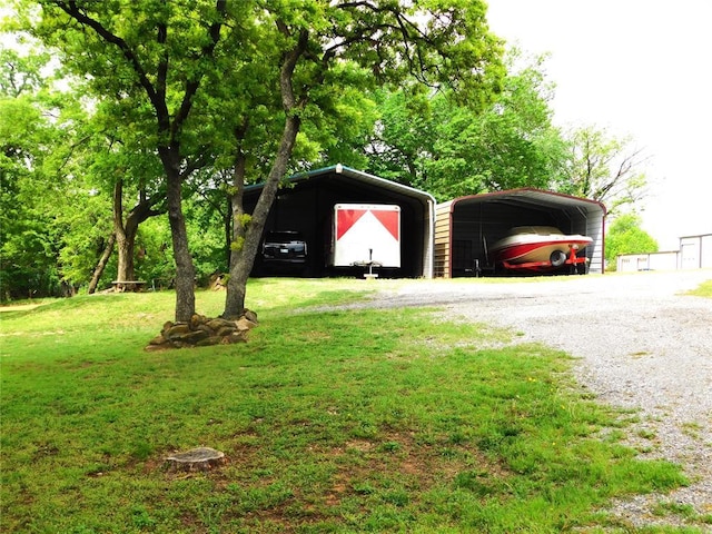 garage featuring a detached carport and gravel driveway