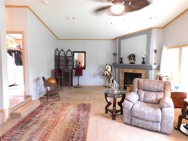 living room with crown molding, a ceiling fan, carpet floors, and a fireplace