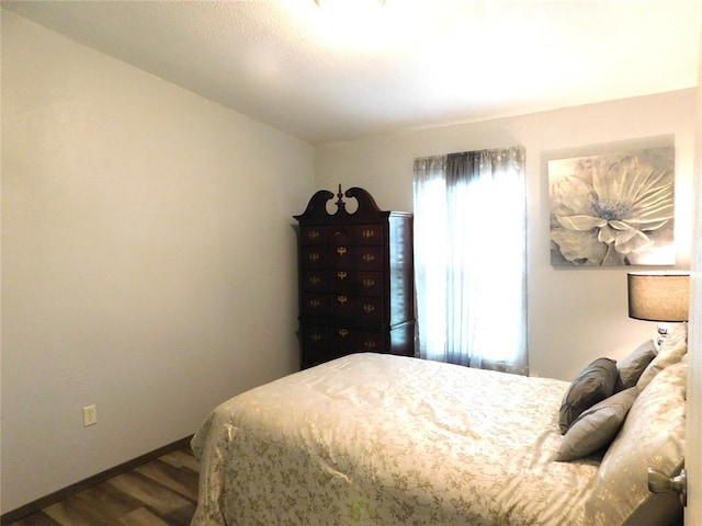bedroom featuring dark wood-style floors and baseboards