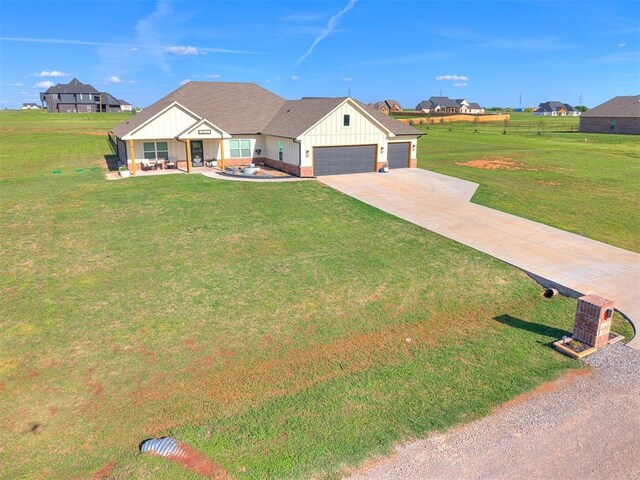 view of front facade featuring a garage, board and batten siding, a front yard, and concrete driveway