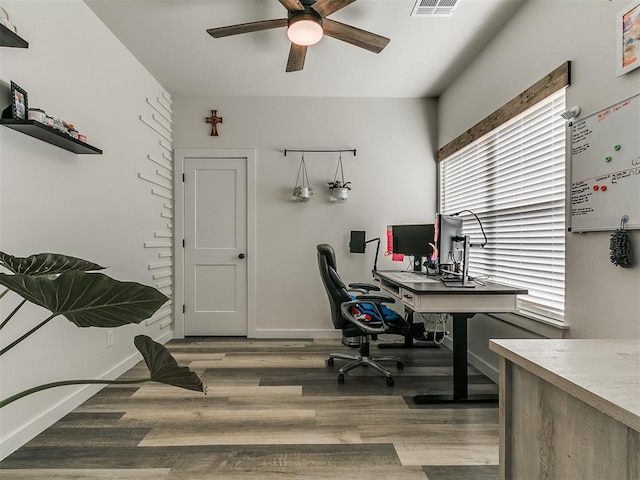 office with a ceiling fan, baseboards, visible vents, and wood finished floors