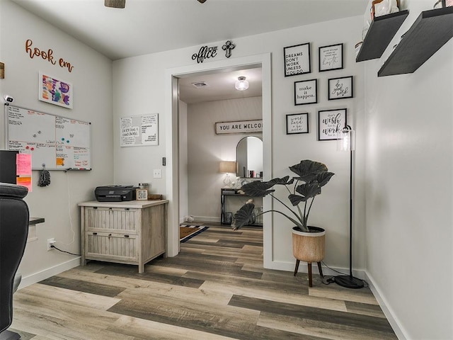 office featuring baseboards, wood finished floors, and visible vents