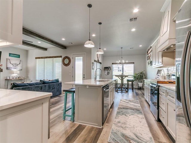 kitchen with visible vents, light wood-type flooring, white cabinetry, a sink, and appliances with stainless steel finishes