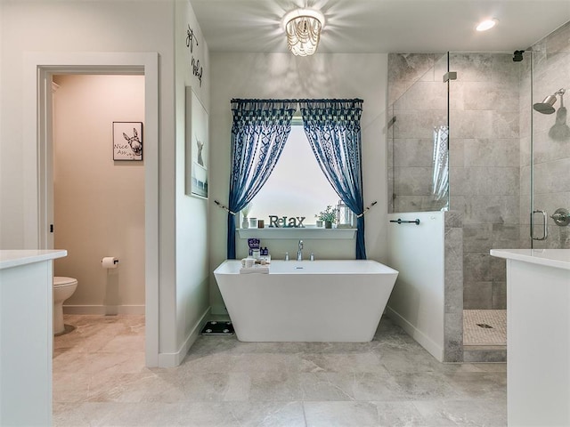 full bath with baseboards, a freestanding tub, a stall shower, and toilet