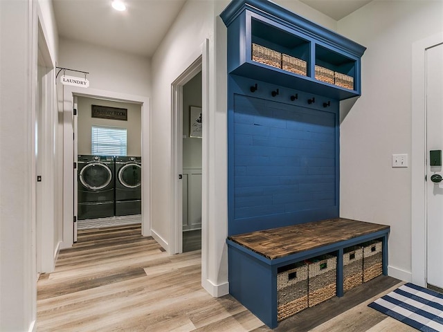 mudroom featuring separate washer and dryer, baseboards, and light wood-type flooring