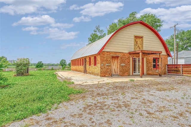 22676 N Rte 66, Clinton, OK 73601 - rear view of property with an outdoor structure, fence, a gambrel roof, brick siding, and a barn