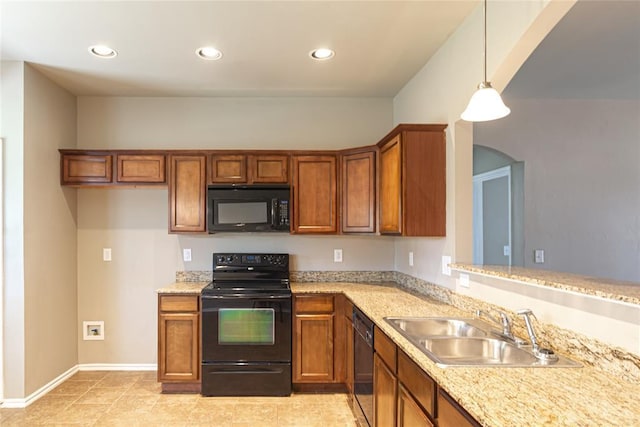 kitchen with brown cabinetry, a sink, arched walkways, and black appliances