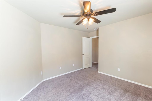 carpeted empty room featuring a ceiling fan and baseboards