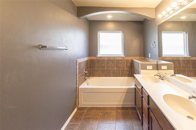 bathroom with baseboards, a sink, and a bath