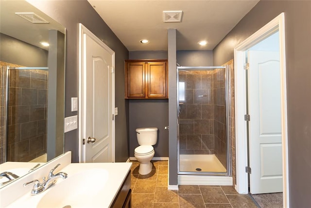 full bathroom featuring visible vents, a shower stall, vanity, baseboards, and toilet