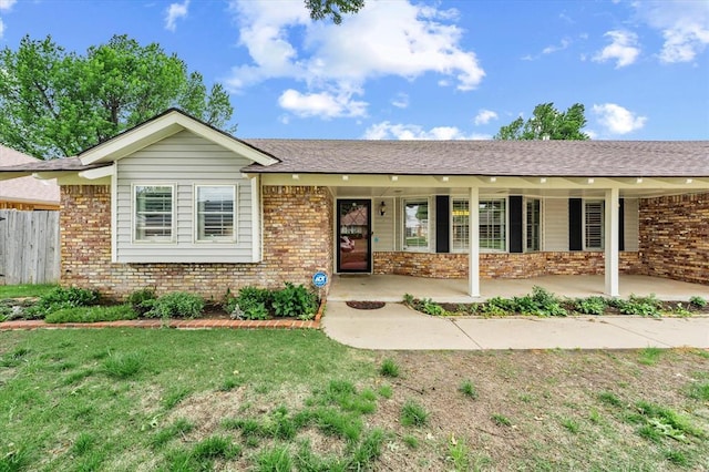 ranch-style house with fence, a front lawn, and brick siding