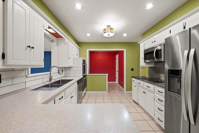 kitchen with stainless steel appliances, white cabinetry, and a sink