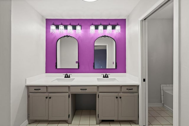 bathroom featuring a sink, tile patterned floors, baseboards, and double vanity